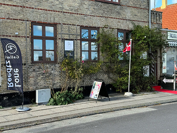 Dragør Havnegalleri udefra med rød løber samt beachflag og skilte om Lone Reedtz fra en anden vinkel